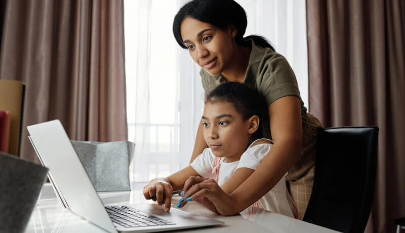 A woman teaching her daughter in laptop